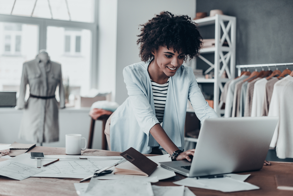 A young woman working on her computer, embodying the success of partnering with a Digital Marketing Agency in New Orleans.