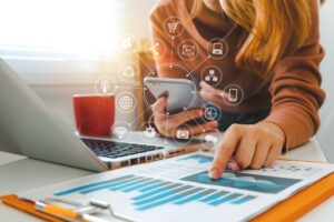 close up of businesswoman working with a phone and laptop with virtual icon diagram. digital marketing agency new orleans.